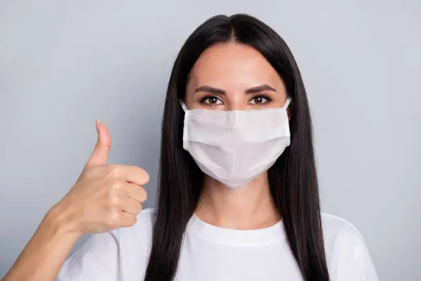 Close-up portrait of nice attractive lovely content healthy straight-haired girl showing thumbup trust solution health quarantine, measure sars isolated on light grey pastel color background