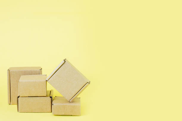 istock Cardboard boxes of various sizes on yellow background. 1254041123
