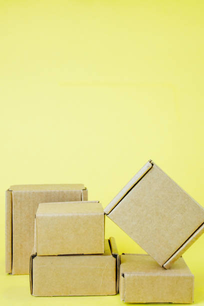 istock Cardboard boxes of various sizes on yellow background. 1254041128