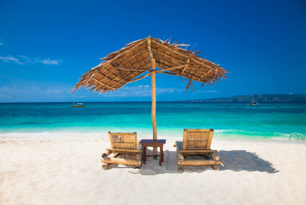 istock Relaxing couch chairs with straw parasol on Puka sandy beach at Boracay. Philippines. 1254041769