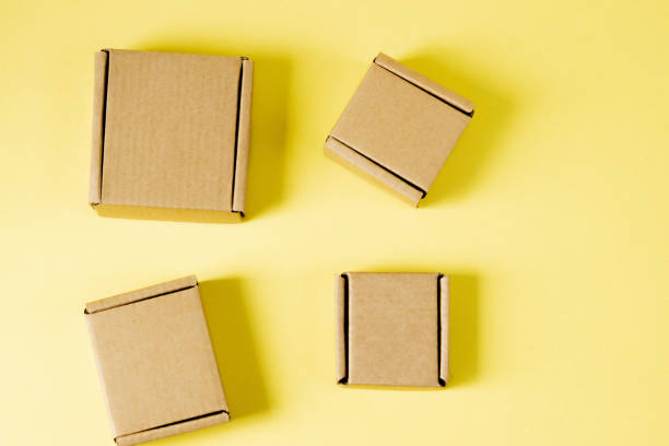 istock Cardboard boxes of various sizes on yellow background. 1254043572