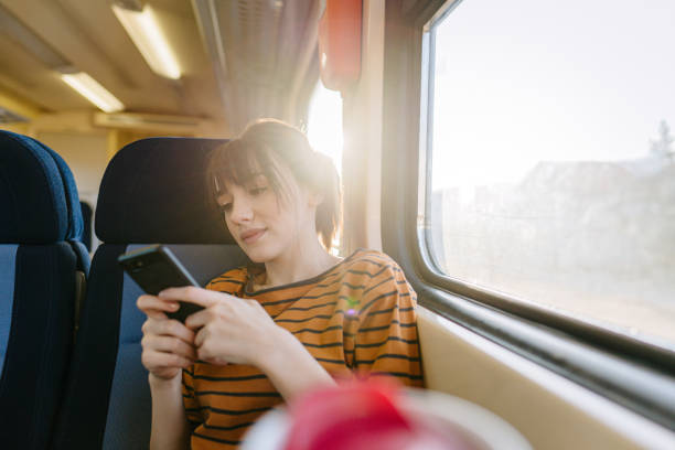 istock Young woman on a train using mobile phone 1254044680