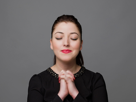 Close up portrait of hopeful woman praying