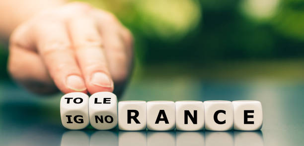 istock Hand turns dice and changes the word ignorance to tolerance. 1254048687