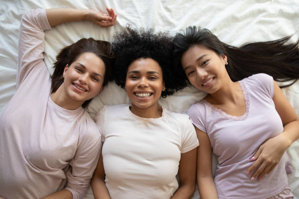 istock Top view three diverse girls best friends lying on bed 1254048991