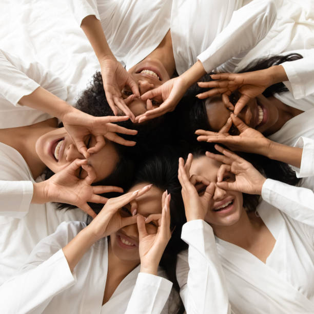 istock Top view funny diverse girls making binoculars, looking at camera 1254049031