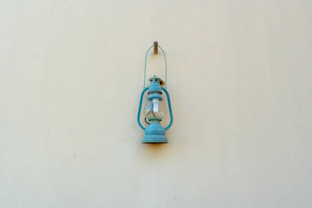 Close up to isolated blue lamp attached to the light colored wall
