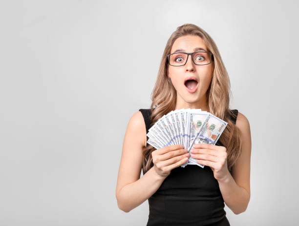 istock Beautiful woman holding dollar on white background 1254050438