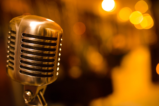 close-up stage retro microphone, orange tint, different focus, copy space