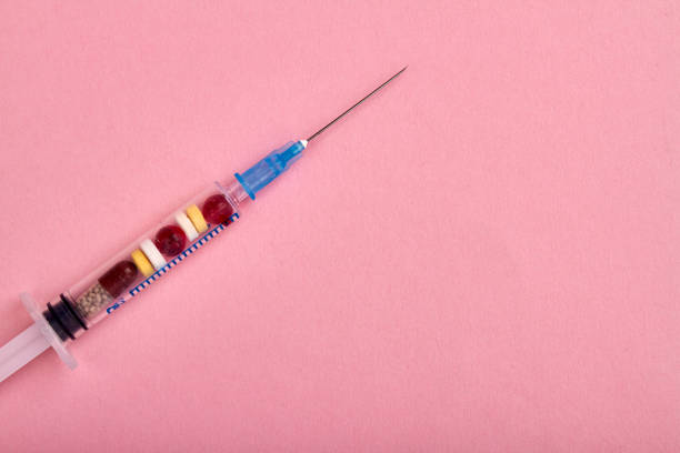 istock Close up syringe filled with pills and tablets. 1254052503