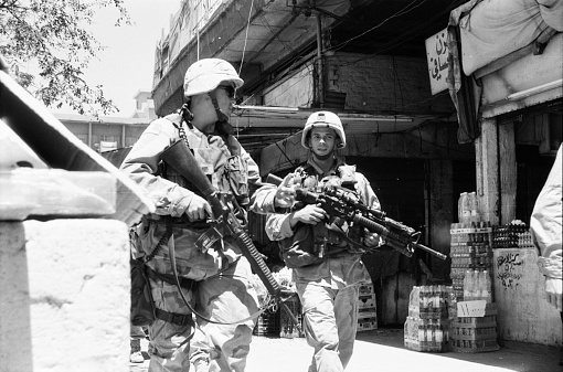 A troop of U.S. soldiers is surveilling the streets of Baghdad. There was a lot of chaos there in 2003 due to criminals and pendants of Saddam Hussein. Photographed by Michael Multhoff in Baghdad / Iraq. May 12, 2003