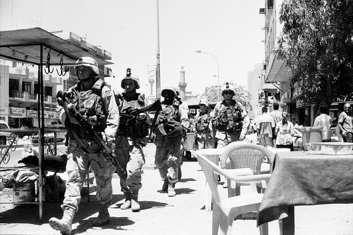 A troop of U.S. soldiers is surveilling the streets of Baghdad. There was a lot of chaos there in 2003 due to criminals and pendants of Saddam Hussein. Photographed by Michael Multhoff in Baghdad / Iraq. May 12, 2003