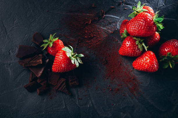istock dessert preparing strawberries in chocolate with cocoa on a dark background. Top view 1254053571