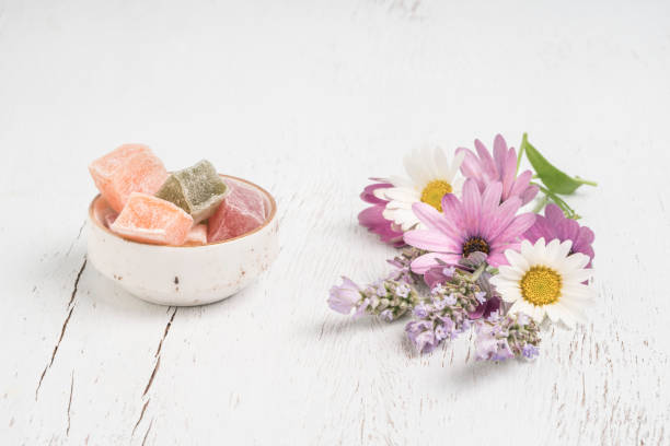 istock colorful Turkish delights and spring flowers on table with copy space 1254054590