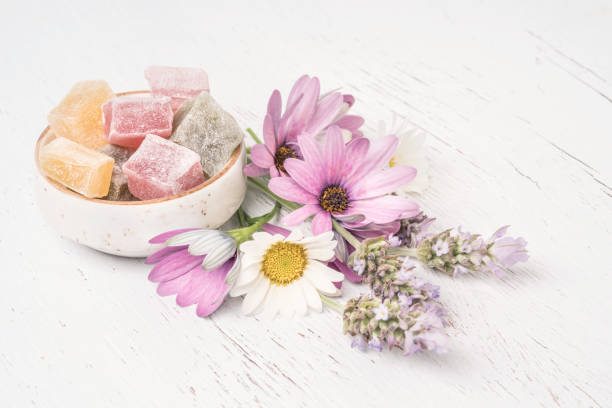 colorful Turkish delights and spring flowers on table with copy space