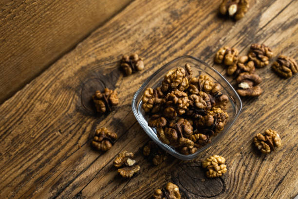 istock Walnut in a smale plate with scattered shelled nuts which standing on a wooden vintage table. Walnuts is a healthy vegetarian protein nutritious food. Walnut on rustic old wood. 1254055172