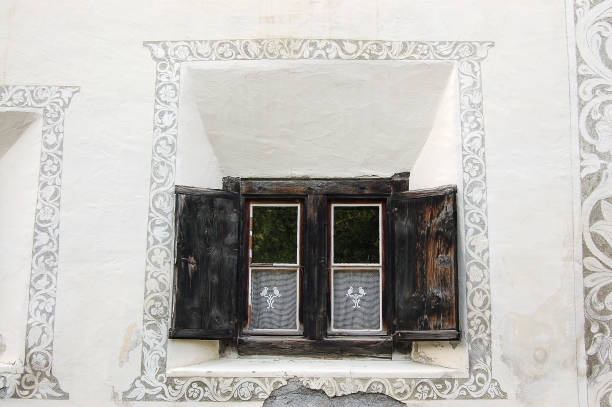 antigua ventana de madera con decoraciones - guarda pueblo engadina suiza - engadine rustic window frame window sill fotografías e imágenes de stock