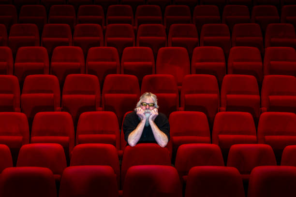 istock One man with white beard sits in Empty cinema or theatre 1254059006