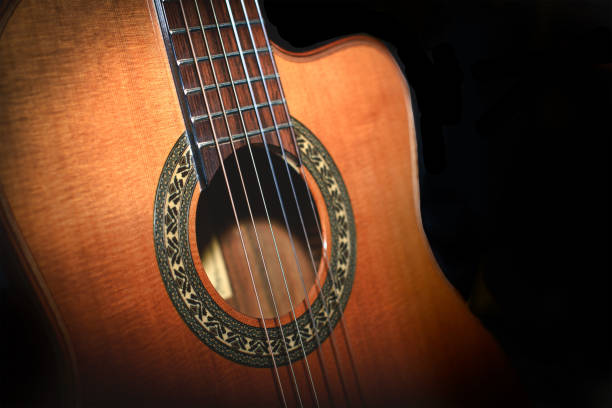 istock Classical guitar detail on black background 1254060496