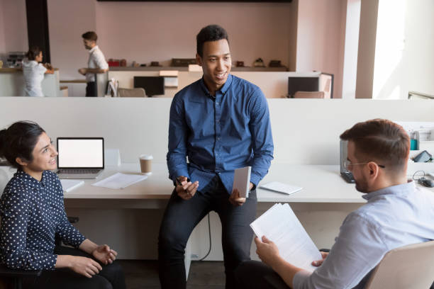 istock Male african american executive discussing paperwork with diverse colleagues 1254060977