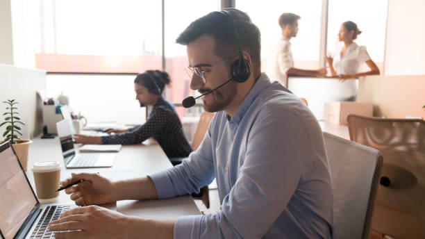 istock Male call center agent using computer in customer care office 1254060988