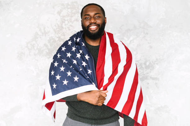 istock African-American guy stands with US flag 1254062324