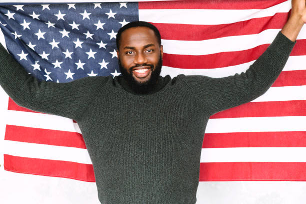 istock African-American guy stands with US flag 1254062337