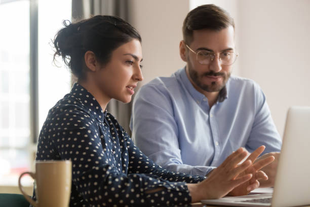 istock Focused male intern listening to indian mentor explaining online strategy 1254063669