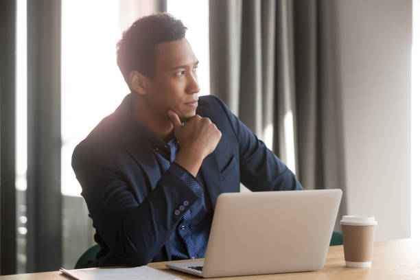 istock Thoughtful african businessman lost in thoughts sit at office desk 1254063699