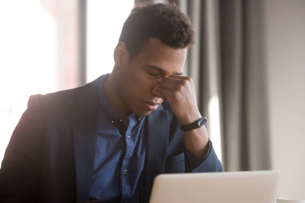 istock Frustrated stressed black businessman feel eye strain headache at work 1254063722
