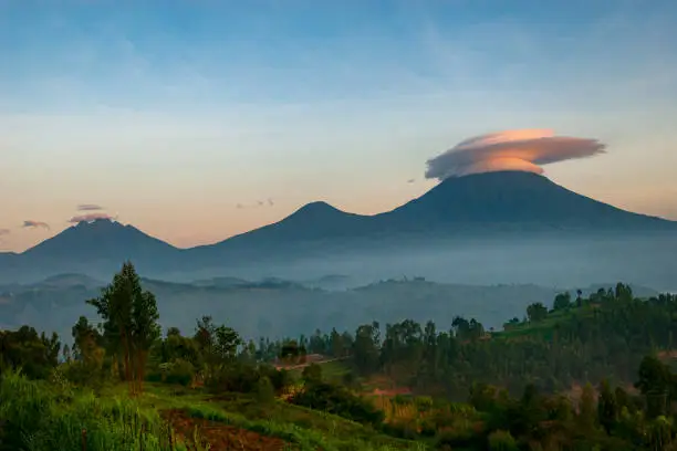 View into the mountain range of the Virunga Volcanoes, a line of 8 volcanoes in the area of the border-triangle between Rwanda, Uganda and the DR Congo. 

Left: Mount Bisoke (3711 m)
Middle: Mount Muhabura (4127m)
Right: Mount Gahinga (3474 m)

The Virunga Volcanoes are home of the critically endangered mountain gorilla (gorilla beringei beringei), listed on the IUCN Red List of Endangered Species due to habitat loss, poaching, disease, and war.