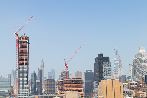 Skyscrapers construction with tower cranes in Long Island City Queens New York with he Manhattan skyline in the background