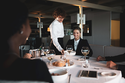 Business people dining in a luxury restaurant enjoying food and discussing of future projects.