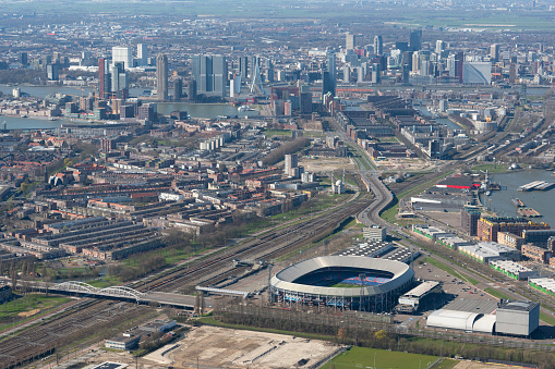Rotterdam, The Netherlands - March 2020: Aerial photo of Feyenoord stadium De Kuip, with all of downtown Rotterdam in the background.