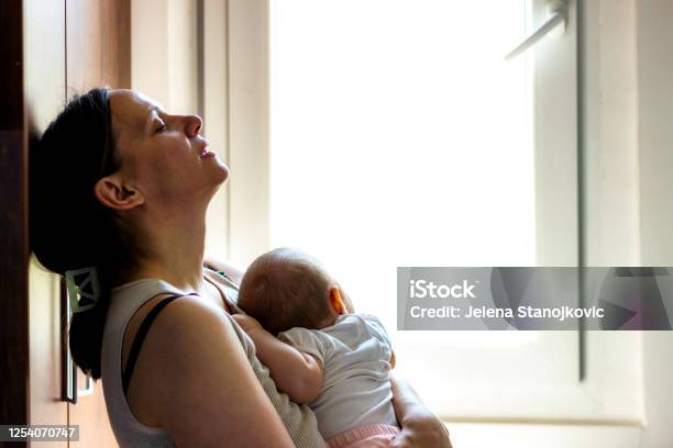 Tired Concerned Mother Rocking Sleeping Baby Stock Photo - Download Image Now - Mother, Postpartum Depression, Baby - Human Age