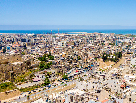 Aerial drone shots of Tripoli showing a medieval castle, and the river and the poor districts.