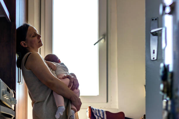 istock Tired concerned mother rocking sleeping baby 1254070843