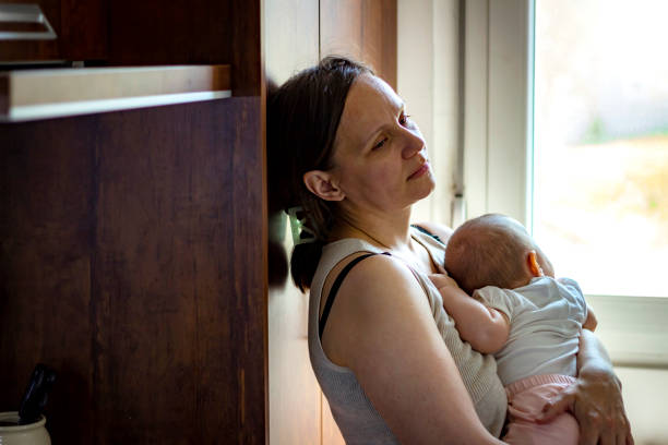 istock Tired concerned mother rocking sleeping baby. 1254070937