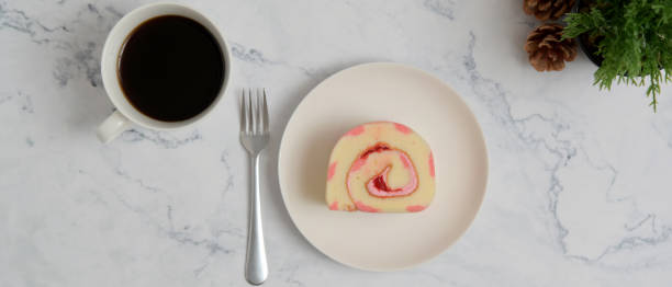 istock Strawberry roll cake and tea on white stone table. 1254070974