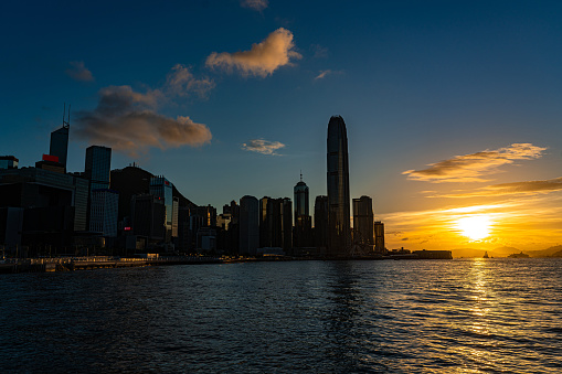 Hong Kong skyline cityscape downtown skyscrapers over Victoria Harbour in the sunset.