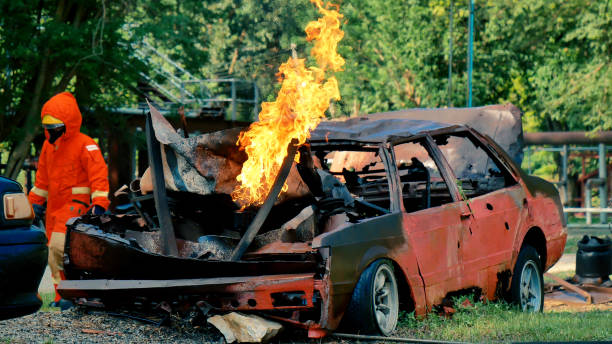 crashed car emitting thick orange smoke during a fire department training exercise