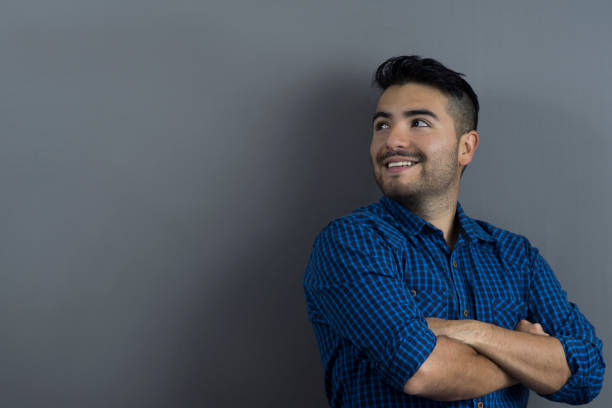 istock Young handsome man daydreaming looking away with arms crossed 1254074082