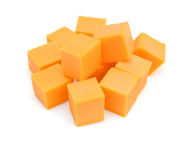 Cubes of cheddar cheese isolated on white Cubes of cheddar cheese isolated on white colby cheddar stock pictures, royalty-free photos & images