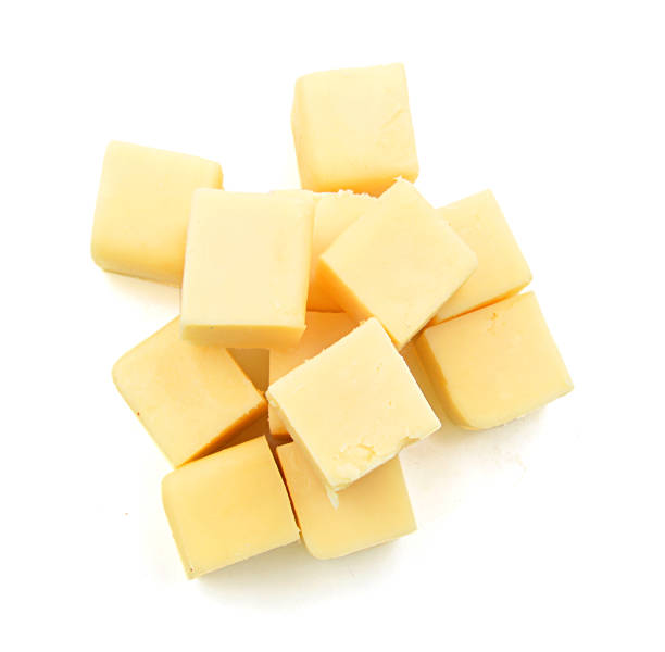 istock Cubes of cheddar cheese isolated on white 1254075174