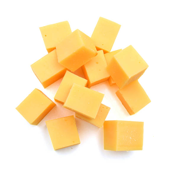 Cubes of cheddar cheese isolated on white Cubes of cheddar cheese isolated on white cheddar cheese stock pictures, royalty-free photos & images