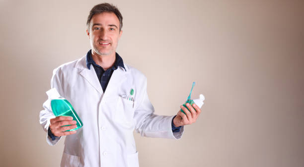 istock Uniformed dentist with products in the hands general view 1254075387