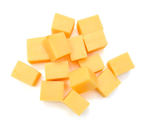 istock Cubes of cheddar cheese isolated on white 1254075400