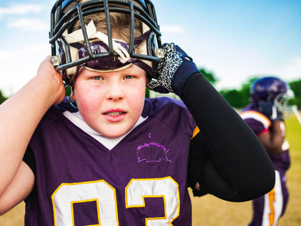 Junior Football player getting helmet ready