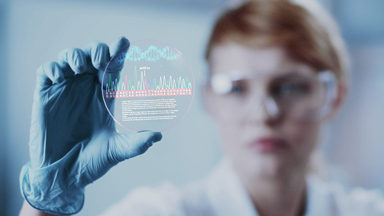Científica femenina estudiando mutaciones en el ADN. Sosteniendo la placa virtual con datos photo
