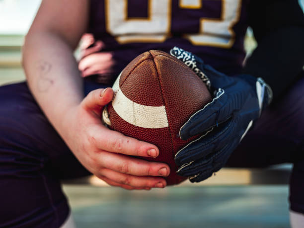 istock Football in the hands during game 1254081967